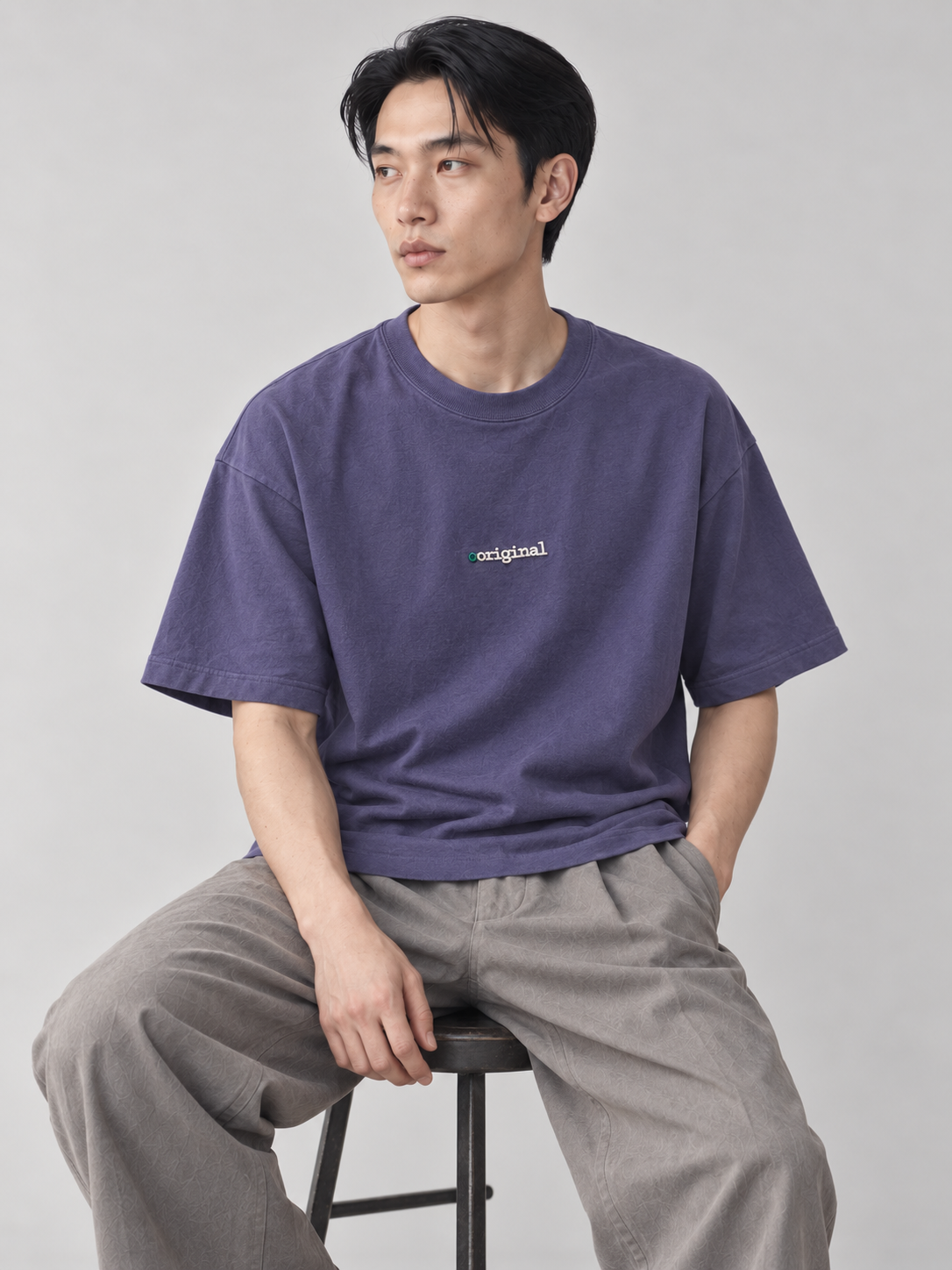 [color:violet] Chest-Embroidery Tee — seated studio model